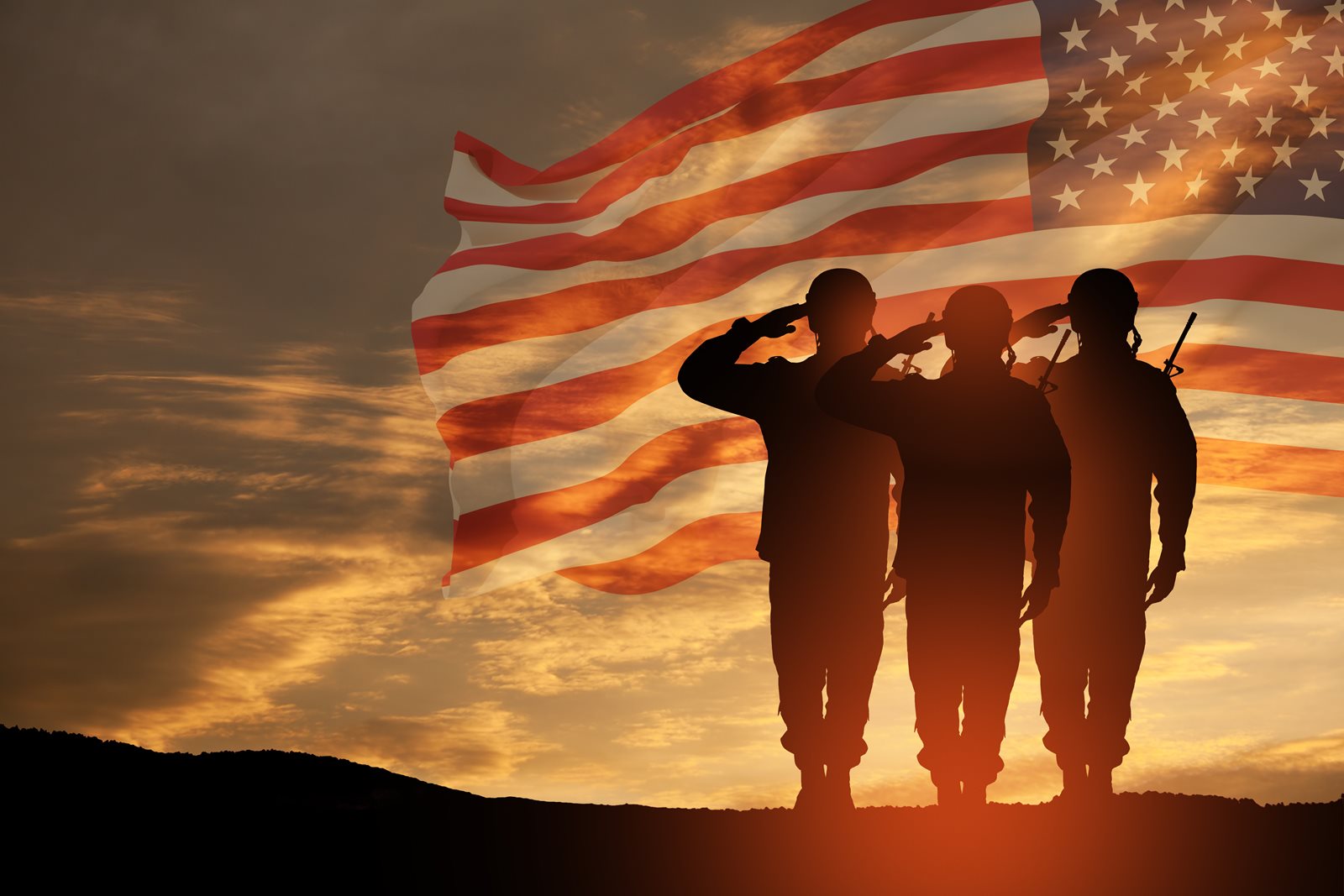 Soldiers standing by the American flag